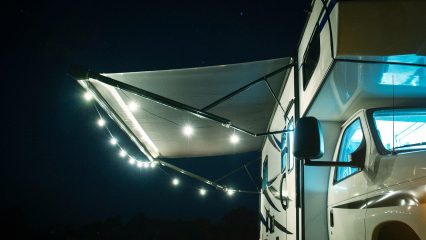Rv awning with led lights at night in forest campsite
