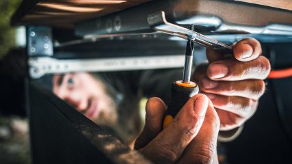 Dan dan the rv man tightening rv slide-out mechanism under camper in greenville sc