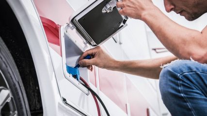 Dan loftis plugging shore power into rv electrical panel during mobile service visit by cavu rv in south carolina