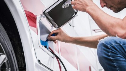 Dan loftis plugging shore power into rv electrical panel during mobile service visit by cavu rv in south carolina